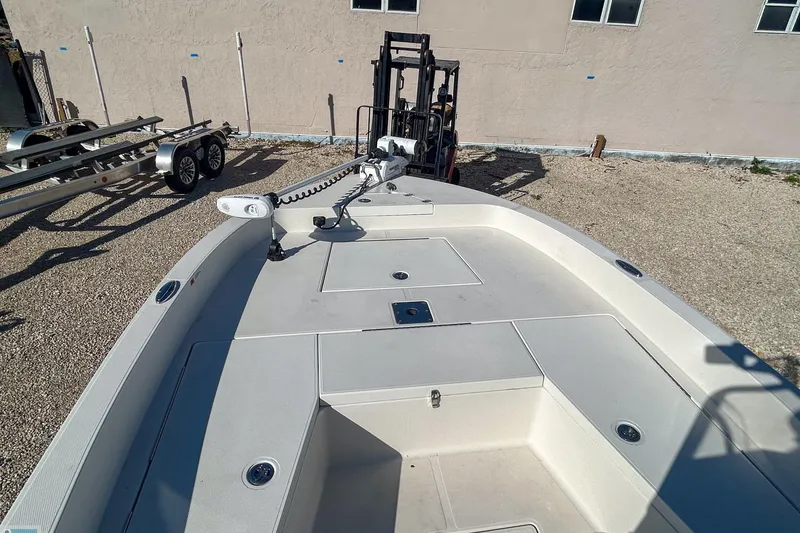 Slide: The Image of 2022 Ranger 2360 Bay boat deck with trolling motor and trailer in background. - 12