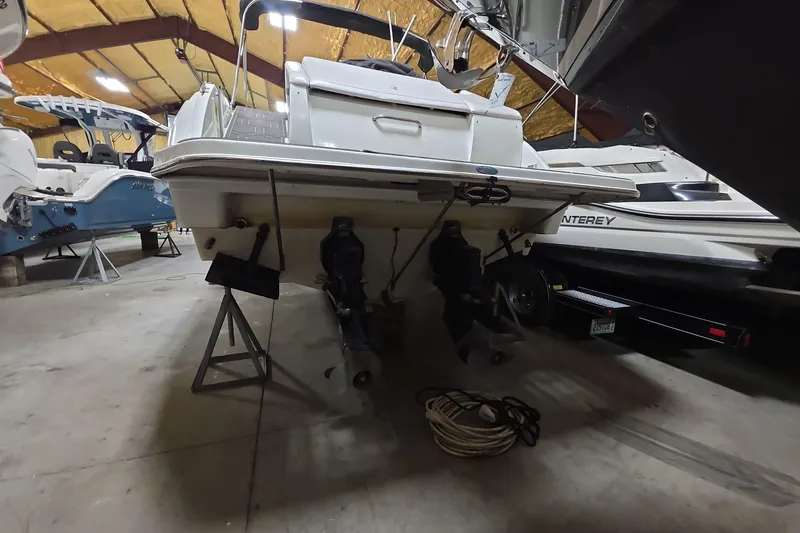 Slide: The Image of 2000 Formula 330 Sun Sport boat in storage, rear view with dual outboard motors. - 14