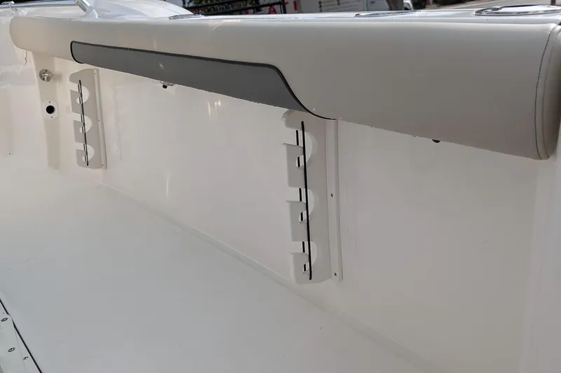 Slide: The Image of 2026 Key West 244 Center Console boat interior with rod holders and cushioned side panel. - 11