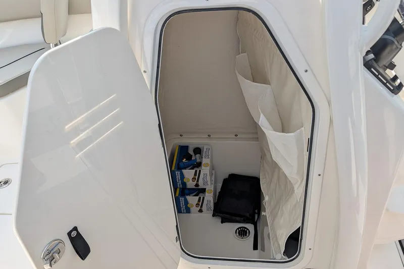 Slide: The Image of Storage compartment of 2026 Key West 244 Center Console boat, open with items inside. - 14