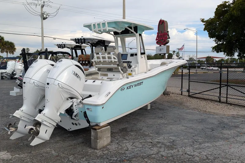 Slide: The Image of 2026 Key West 244 Center Console boat with twin Yamaha engines, parked outdoors. - 4