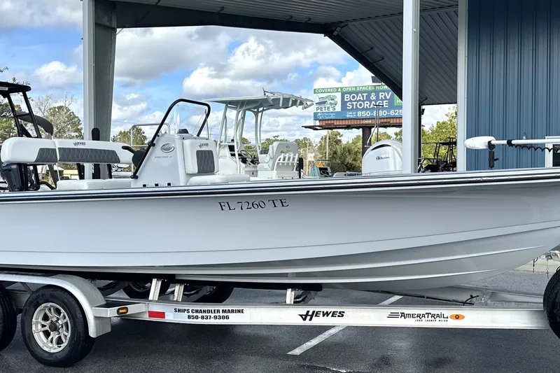 Slide: The Image of 2022 Hewes Redfisher 21 boat on trailer, parked under a canopy. - 20