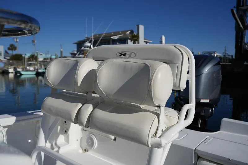 Slide: The Image of 2020 Sea Hunt BX 20 BR boat with white cushioned seating, docked in marina. - 23