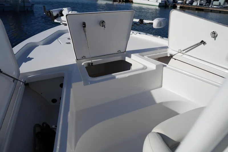 Slide: The Image of 2020 Sea Hunt BX 20 BR boat with open storage compartments at a marina. - 40