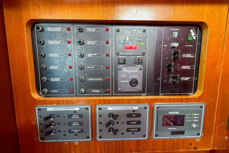 Slide: The Image of Control panel of a 1998 Beneteau Oceanis 36 CC sailboat, featuring various switches and displays. - 25