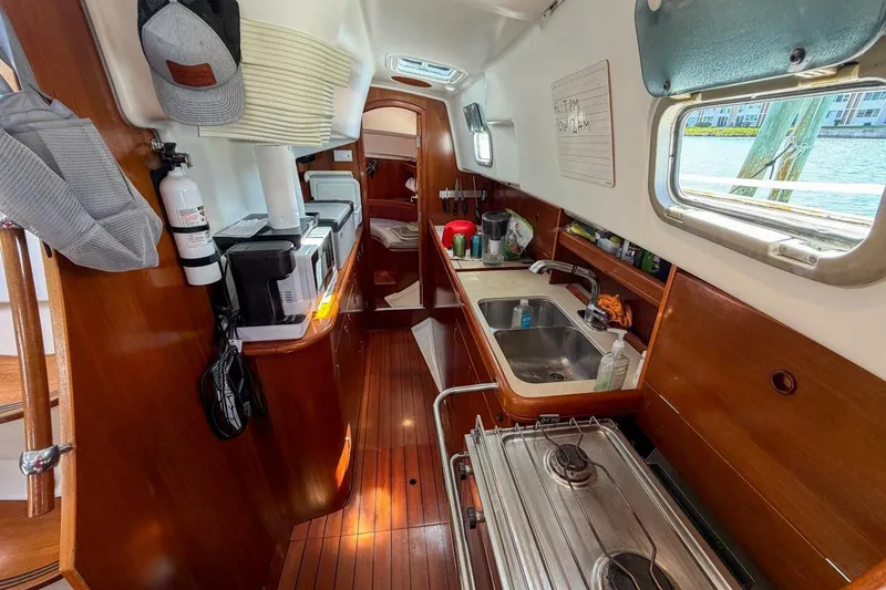 Slide: The Image of Interior of 1998 Beneteau Oceanis 36 CC sailboat, featuring a compact kitchen area. - 29