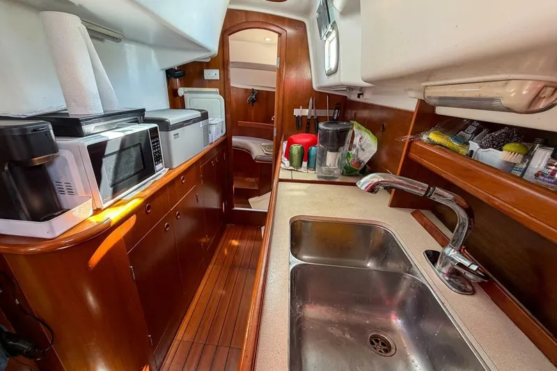 Slide: The Image of Galley kitchen in 1998 Beneteau Oceanis 36 CC sailboat with appliances and wooden cabinetry. - 30