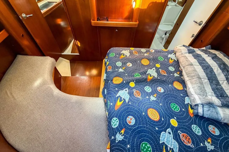 Slide: The Image of Cozy cabin interior of 1998 Beneteau Oceanis 36 CC with space-themed bedding. - 35