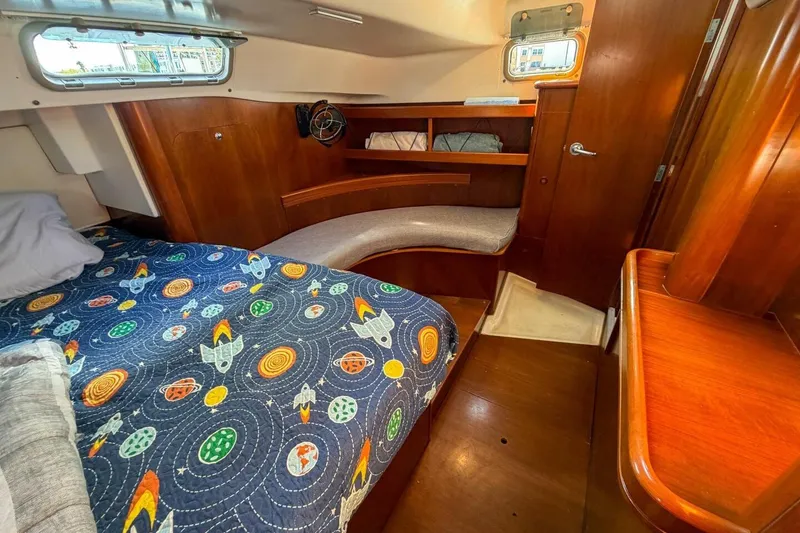 Slide: The Image of Cozy cabin interior of 1998 Beneteau Oceanis 36 CC with colorful bedding and wooden furnishings. - 39