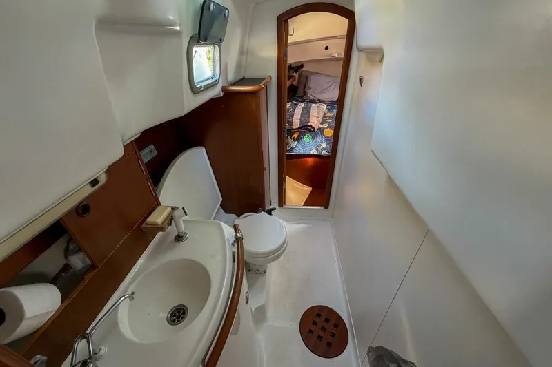 Slide: The Image of Beneteau Oceanis 36 CC 1998 yacht bathroom with sink, toilet, and cabin view. - 42
