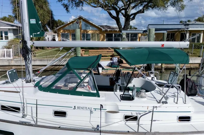 Slide: The Image of 1998 Beneteau Oceanis 36 CC sailboat docked, featuring green canopy and sleek design. - 48