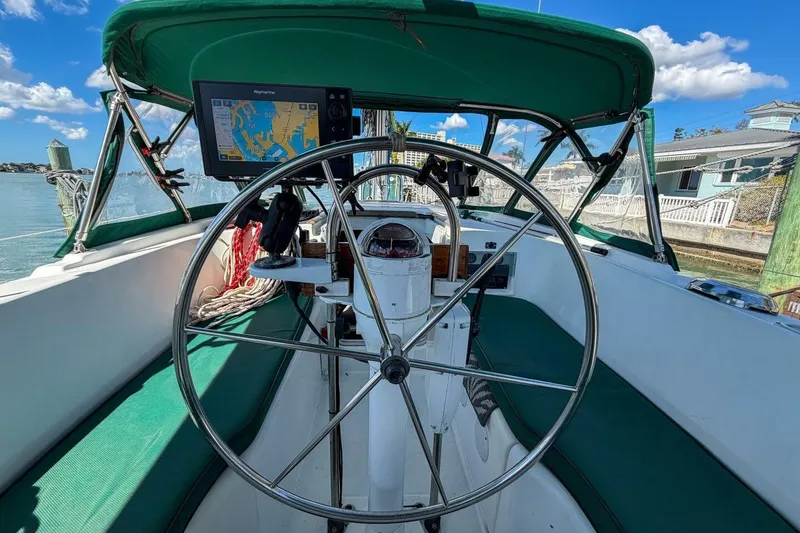 Slide: The Image of Cockpit of 1998 Beneteau Oceanis 36 CC sailboat with navigation equipment and green canopy. - 52