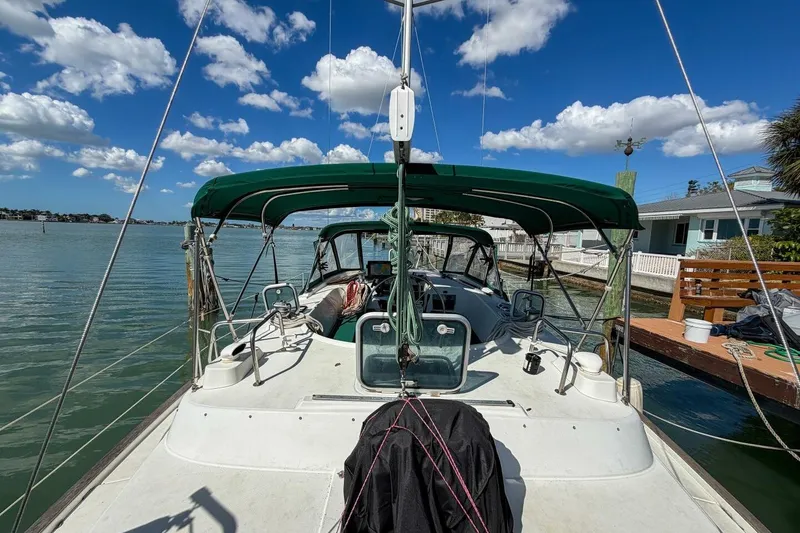 Slide: The Image of 1998 Beneteau Oceanis 36 CC sailboat docked, featuring green canopy and clear blue sky. - 60