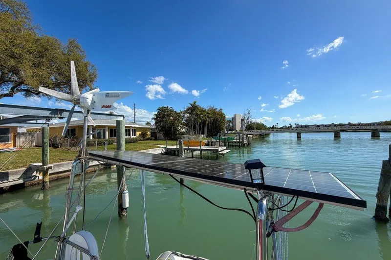 Slide: The Image of Solar panel and wind turbine on a 1998 Beneteau Oceanis 36 CC sailboat by a scenic waterfront. - 63