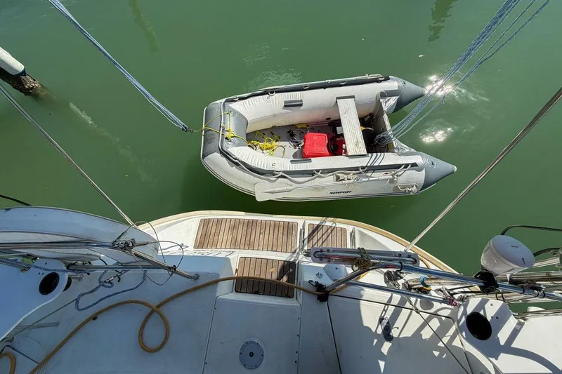 Slide: The Image of Beneteau Oceanis 36 CC sailboat with dinghy, 1998 model, docked on calm water. - 64