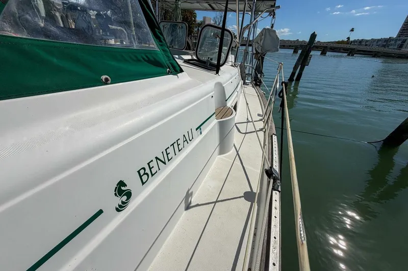 Slide: The Image of 1998 Beneteau Oceanis 36 CC sailboat docked, featuring green canopy and sleek design. - 65