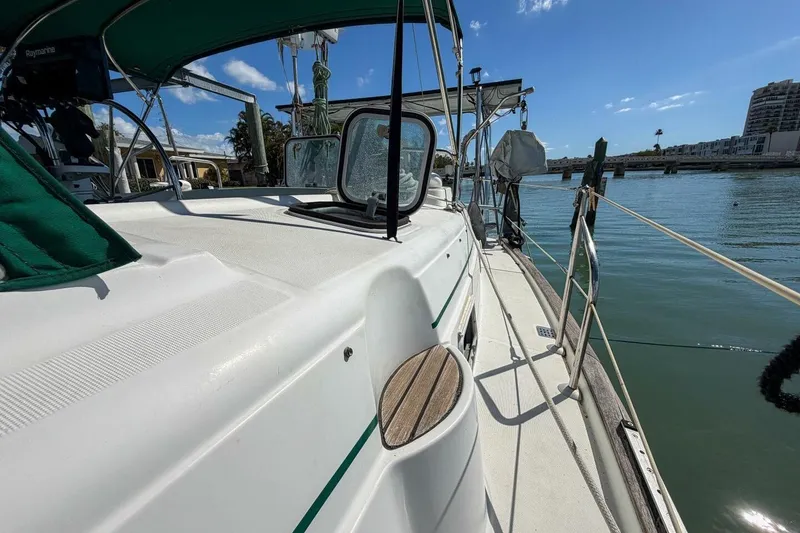 Slide: The Image of 1998 Beneteau Oceanis 36 CC sailboat docked, featuring deck and railing under clear sky. - 66