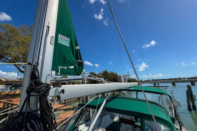 Slide: The Image of 1998 Beneteau Oceanis 36 CC sailboat with green Mack Sails, docked under clear blue sky. - 67