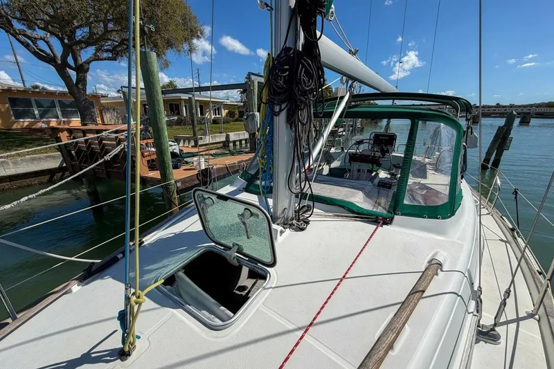 Slide: The Image of 1998 Beneteau Oceanis 36 CC sailboat docked, featuring open hatch and green canopy. - 68