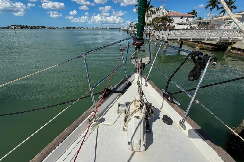 Slide: The Image of Bow view of 1998 Beneteau Oceanis 36 CC sailboat docked by a scenic waterfront. - 71