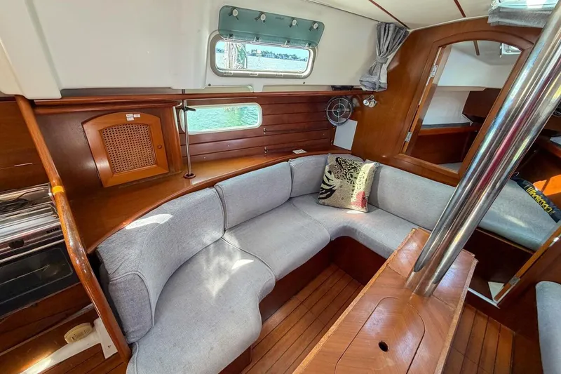 Slide: The Image of Interior of 1998 Beneteau Oceanis 36 CC sailboat with cozy seating and wooden finishes. - 8
