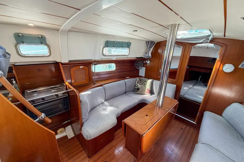 Slide: The Image of Interior of 1998 Beneteau Oceanis 36 CC sailboat with cozy seating and wooden finishes. - 9