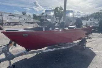 Slide: The Image of 2026 Lund 1650 Angler SS boat in red, parked on a trailer at a marina. - 4