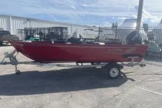 Slide: The Image of 2026 Lund 1650 Angler SS boat in red, parked on a trailer outdoors. - 5