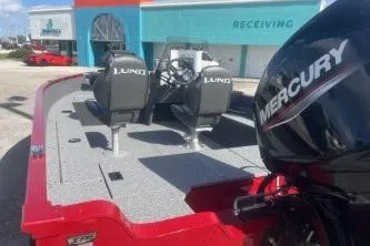 Slide: The Image of 2026 Lund 1650 Angler SS boat with Mercury engine, parked outside a building. - 7