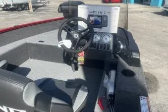 Slide: The Image of 2026 Lund 1650 Angler SS boat interior with steering wheel and control panel. - 8
