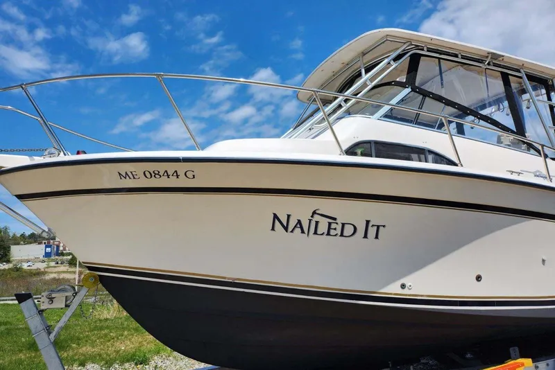 Slide: The Image of 1999 Grady-White Marlin 300 boat named "Nailed It" on trailer, clear sky background. - 3