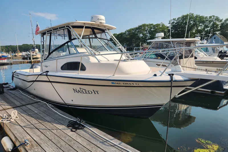 Slide: The Image of 1999 Grady-White Marlin 300 boat docked at marina, named "Nailed It." - 5