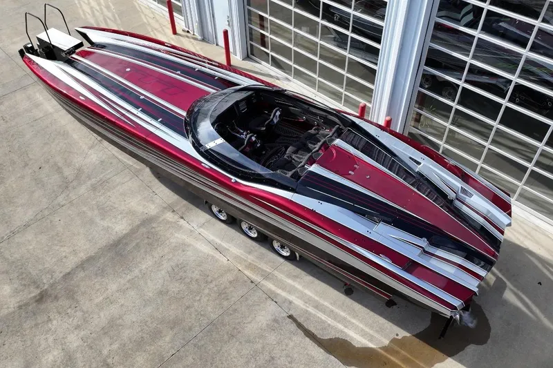 Slide: The Image of 2018 MTI 43 R/P powerboat with sleek red and black design, parked on concrete. - 3