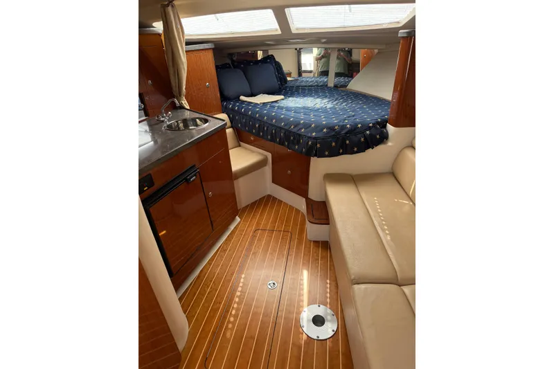 Slide: The Image of 2010 Regal 3360 Window Express cabin interior with bed, kitchenette, and seating area. - 7