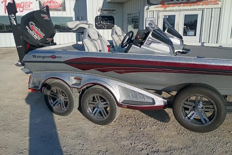 Slide: The Image of 2023 Ranger Z520R boat with sleek design and triple-axle trailer parked outside dealership. - 11