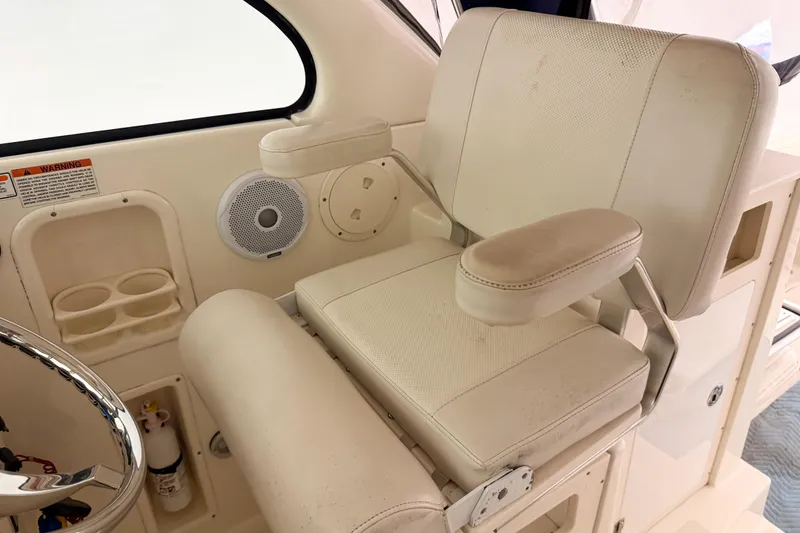 Slide: The Image of Captain's chair on 2007 Pursuit OS 335 Offshore boat, featuring armrests and cup holders. - 10