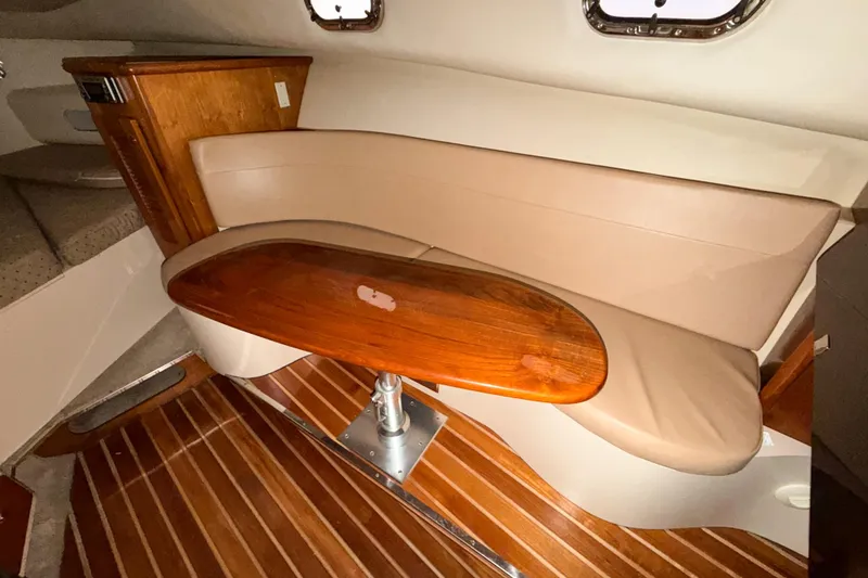 Slide: The Image of Interior of 2007 Pursuit OS 335 Offshore with wooden table and beige seating. - 11