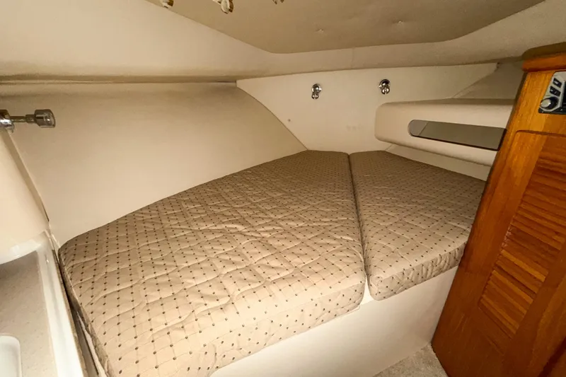 Slide: The Image of 2007 Pursuit OS 335 Offshore cabin interior with cozy bed and wooden accents. - 13