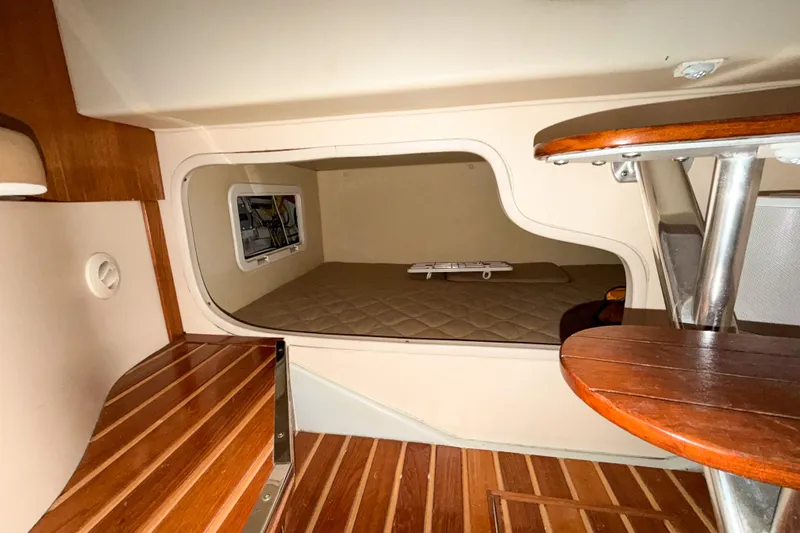 Slide: The Image of 2007 Pursuit OS 335 Offshore cabin interior with wooden flooring and cozy sleeping area. - 16