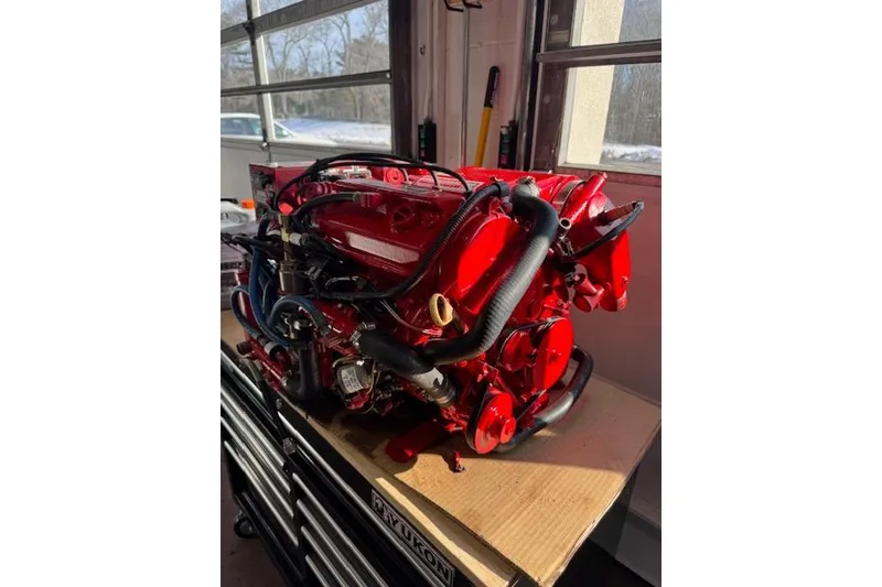 Slide: The Image of Red engine of a 2007 Pursuit OS 335 Offshore boat in a garage setting. - 23
