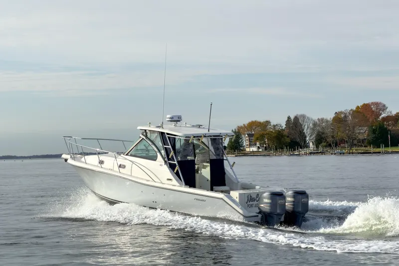 Slide: The Image of 2007 Pursuit OS 335 Offshore boat cruising on a calm lake with scenic shoreline. - 5