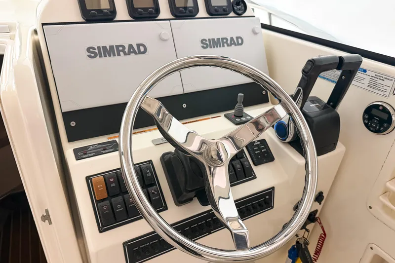 Slide: The Image of 2007 Pursuit OS 335 Offshore helm with Simrad electronics and chrome steering wheel. - 8