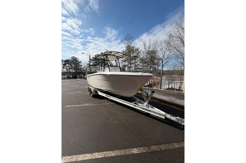 The Image of 2024 Aquasport 2100 Center Console boat on trailer in parking lot. - 1