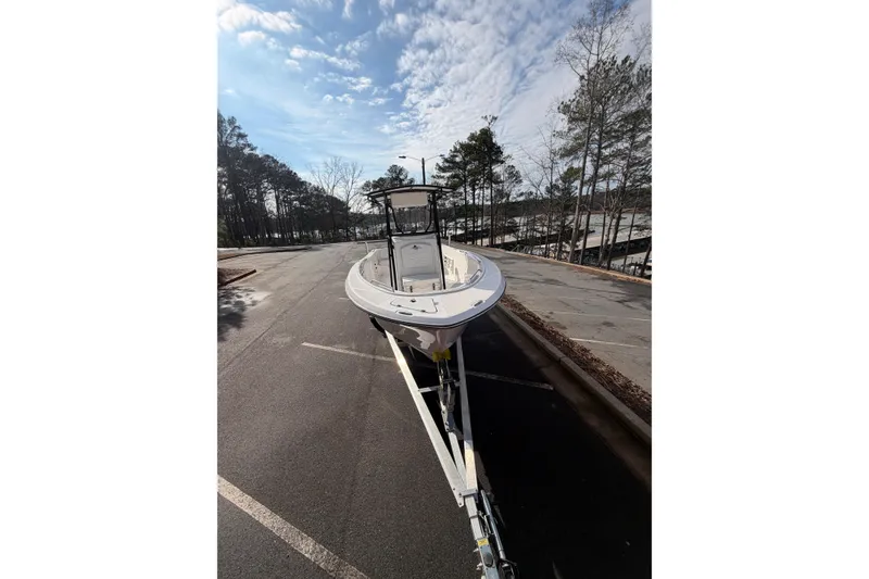 Slide: The Image of 2024 Aquasport 2100 Center Console boat on trailer under a partly cloudy sky. - 10