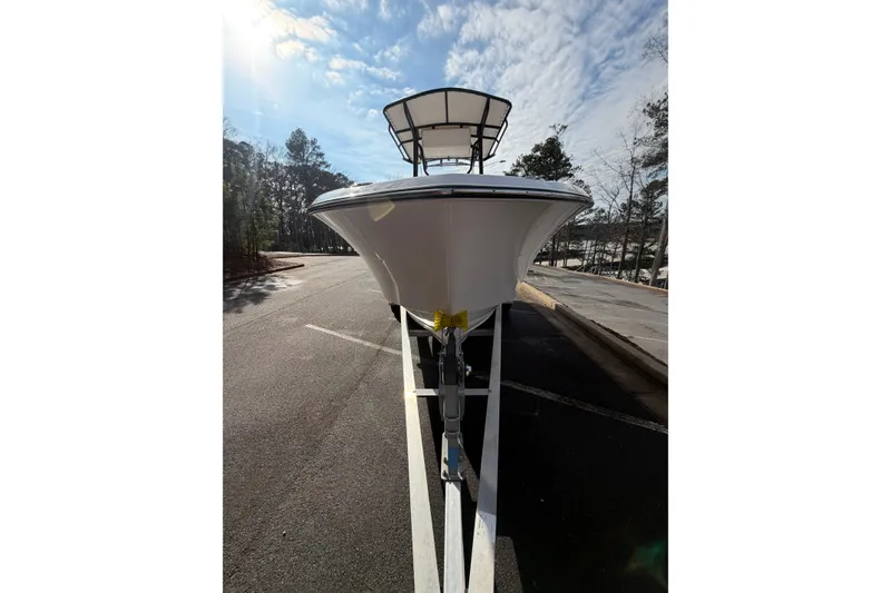 Slide: The Image of 2024 Aquasport 2100 Center Console boat on trailer, viewed from front under sunny sky. - 11