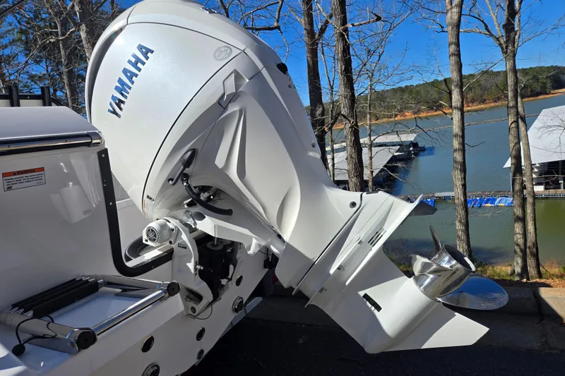 Slide: The Image of 2024 Aquasport 2100 Center Console with Yamaha outboard motor by a lake. - 23