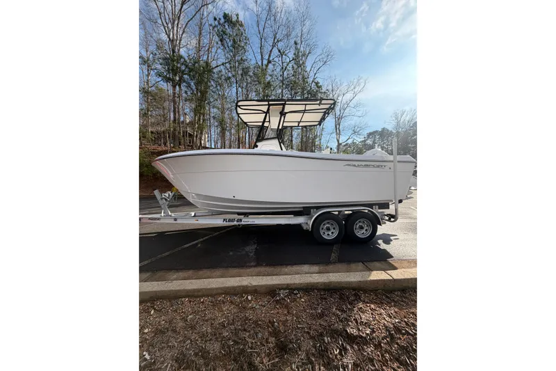 Slide: The Image of 2024 Aquasport 2100 Center Console boat on trailer, parked outdoors. - 7