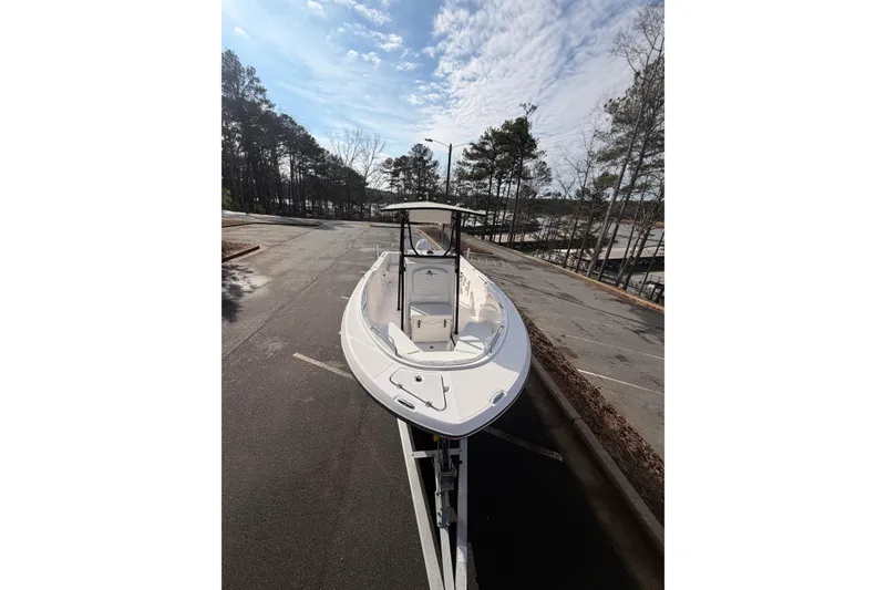 Slide: The Image of 2024 Aquasport 2100 Center Console boat parked outdoors under a cloudy sky. - 9