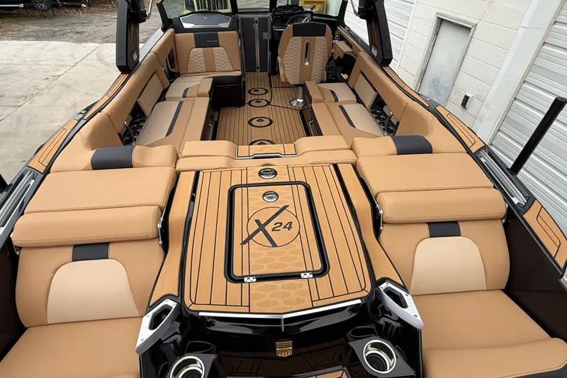 Slide: The Image of 2025 MasterCraft X24 boat interior with tan and black seating, showcasing luxury and spacious design. - 2
