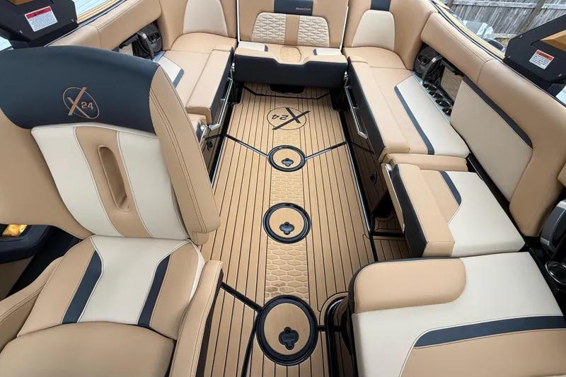 Slide: The Image of 2025 MasterCraft X24 interior with luxurious beige and black seating, stylish flooring, and cup holders. - 8